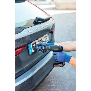 Trapano avvitatore che fissa una targa a un'auto grigia.