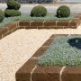 Esempio di design del giardino con bordure t.b.t. e vialetto di ghiaia.