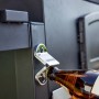 Apribottiglie sulla griglia a carbone t.b.t. che apre una bottiglia di birra.
