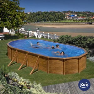 Piscina ovale Gre Pool Pacific effetto legno, 730x375x120 cm, con persone che fanno il bagno in giardino.