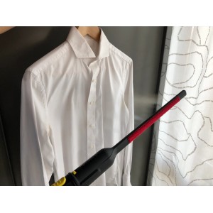 Spazzola a vapore che liscia una camicia bianca. Ideale per la cura rapida dei tessuti.