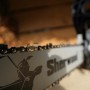 Primo piano di una motosega t.b.t. con catena affilata e logo "Sherwood".