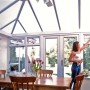 Donna pulisce veranda con lastre in plastica t.b.t. e pannelli alveolari come tetto.