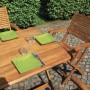 Tavolo da giardino in legno con sedie e piatti verdi, ideale per mangiare all'aperto.
