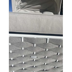 Dettaglio del lettino/sdraio t.b.t. con cuscino grigio e design intrecciato.