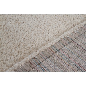 Dettaglio di un tappeto a pelo lungo beige.