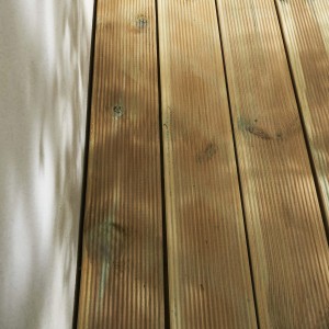 Piastrelle in legno per esterni, superficie scanalata, colore legno naturale.