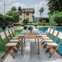 Set tavolo da giardino con tavolo e sedie in legno a bordo piscina. Ideale per feste in giardino.