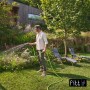 Uomo annaffia il giardino con tubo per irrigazione t.b.t.. Ideale per la cura del giardino.