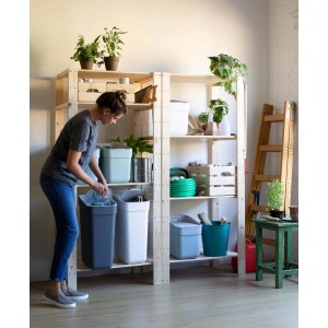 Donna riempie un bidone grigio t.b.t. Sistema di smistamento con contenitori multipli su scaffale.