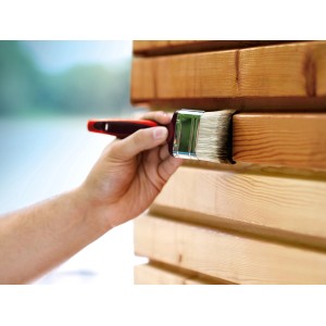 Mano che dipinge il legno con un pennello del set di pennelli da 6 pezzi.