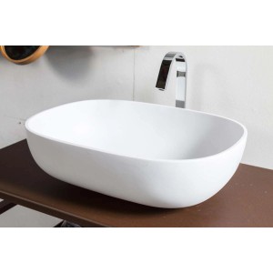 Lavabo d'appoggio bianco t.b.t. con rubinetto su ripiano marrone.