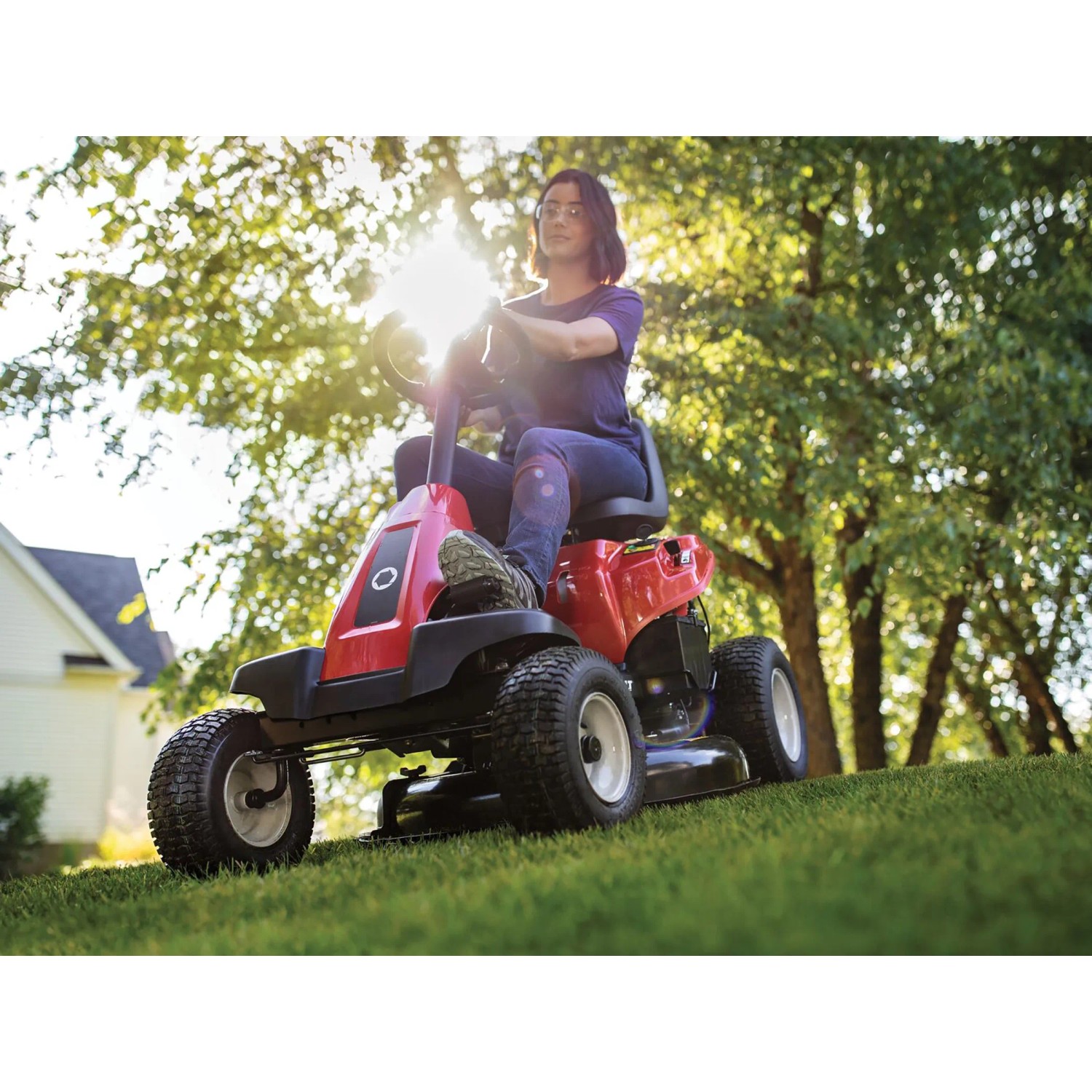 Tosaerba rider Troy-Bilt Mini-Rider 76T-S rosso con scarico laterale durante il taglio.