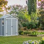 Casetta da giardino in plastica Keter Manor 65DD grigio-bianca in giardino.