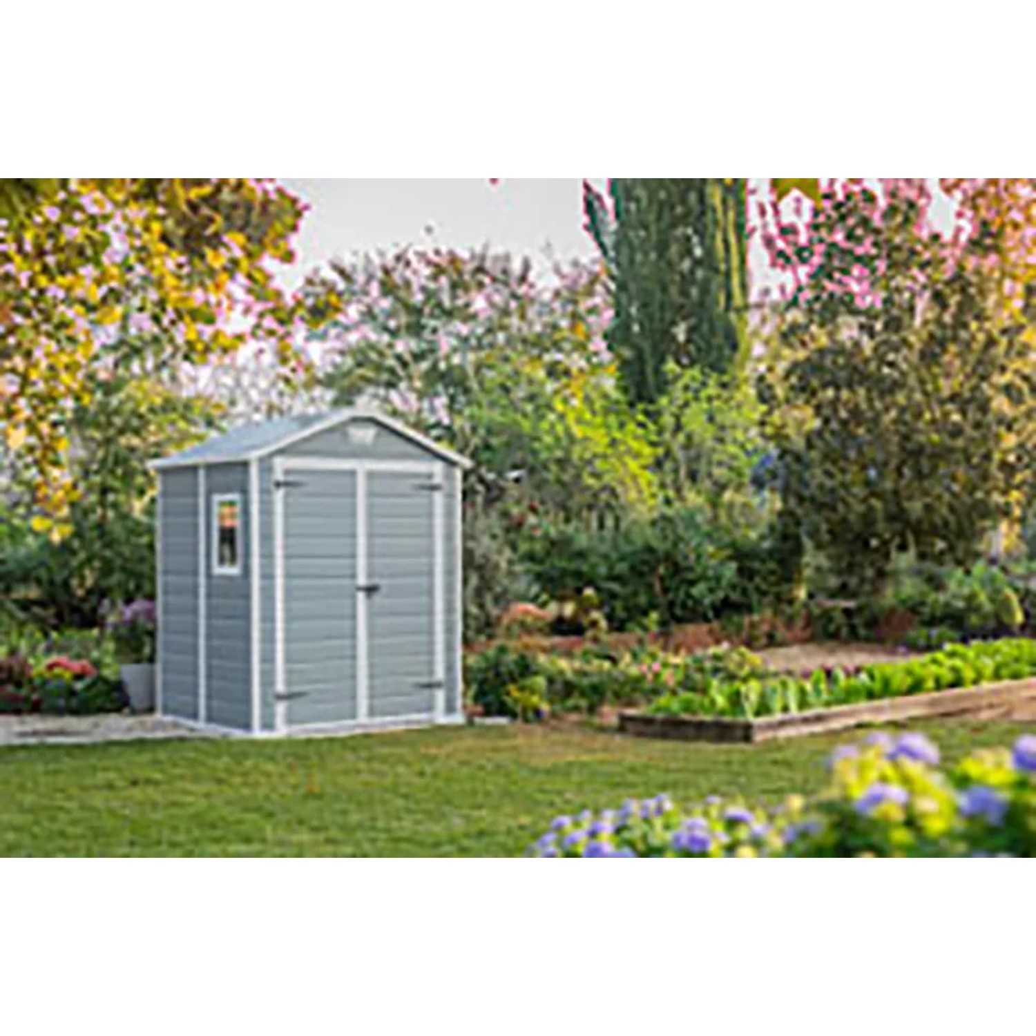 Casetta da giardino in plastica Keter Manor 65DD grigio-bianca in giardino.