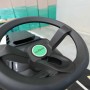 Dettaglio del volante di un trattorino tagliaerba. Volante nero con logo verde.