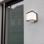 Lampada da parete solare a LED Lutec Doblo color antracite con sensore di movimento su muro bianco.
