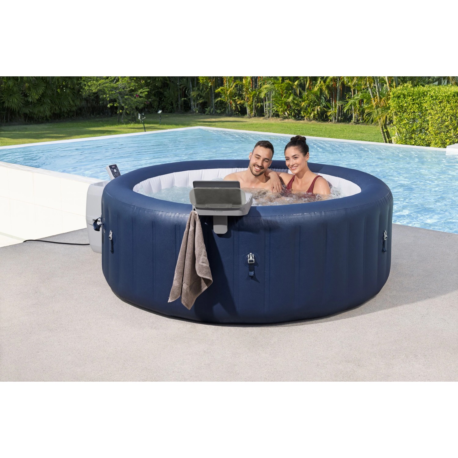 Vassoio Bestway LAY-Z-SPA fissato alla vasca idromassaggio con coppia e piscina sullo sfondo.