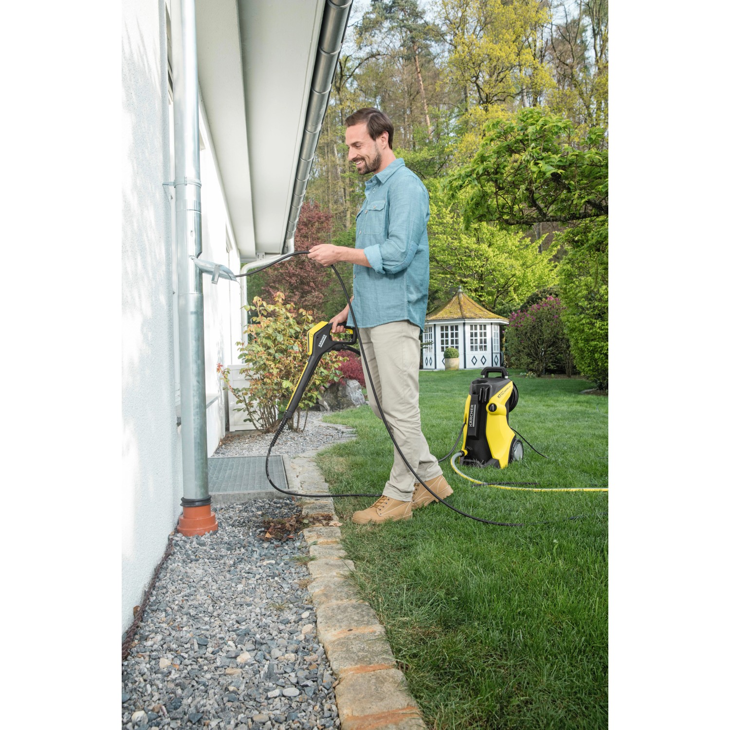 Uomo pulisce la grondaia con idropulitrice Kärcher e tubo di pulizia tubi da 7,5 m.