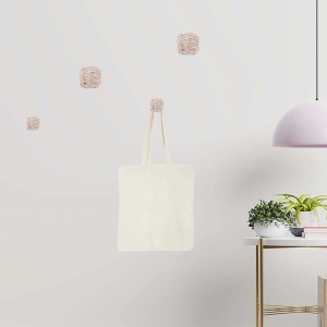 Appendiabiti a muro t.b.t. con quattro ganci a forma di cubo, uno con una borsa di stoffa.