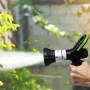 Pistola per irrigazione nera con dettagli argentati e manico verde in mano.