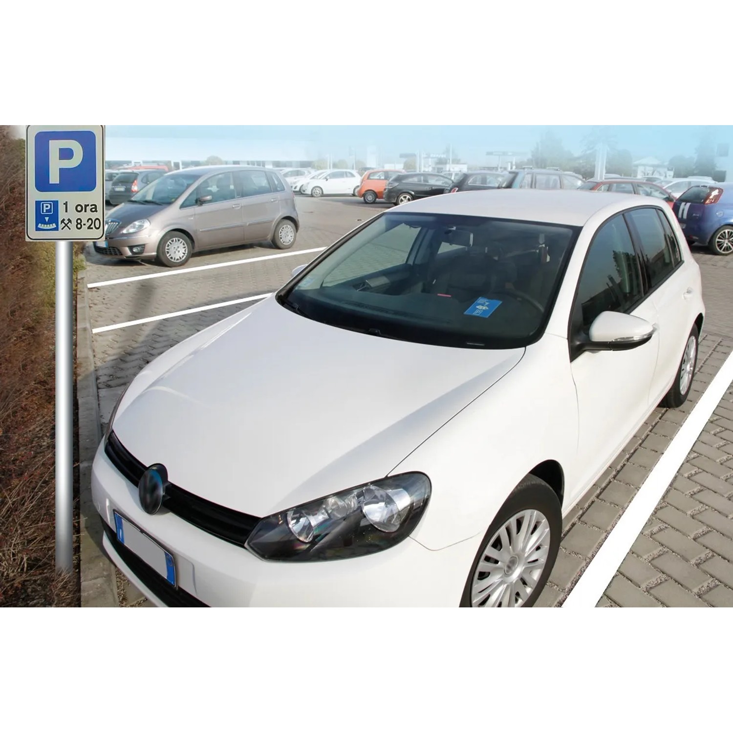Auto bianca parcheggiata in un parcheggio con cartello. Accessori auto interni.