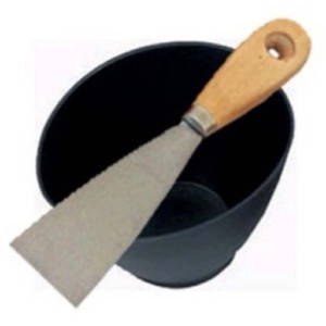 Spatola con manico in legno in secchio nero per lavori di stucco.