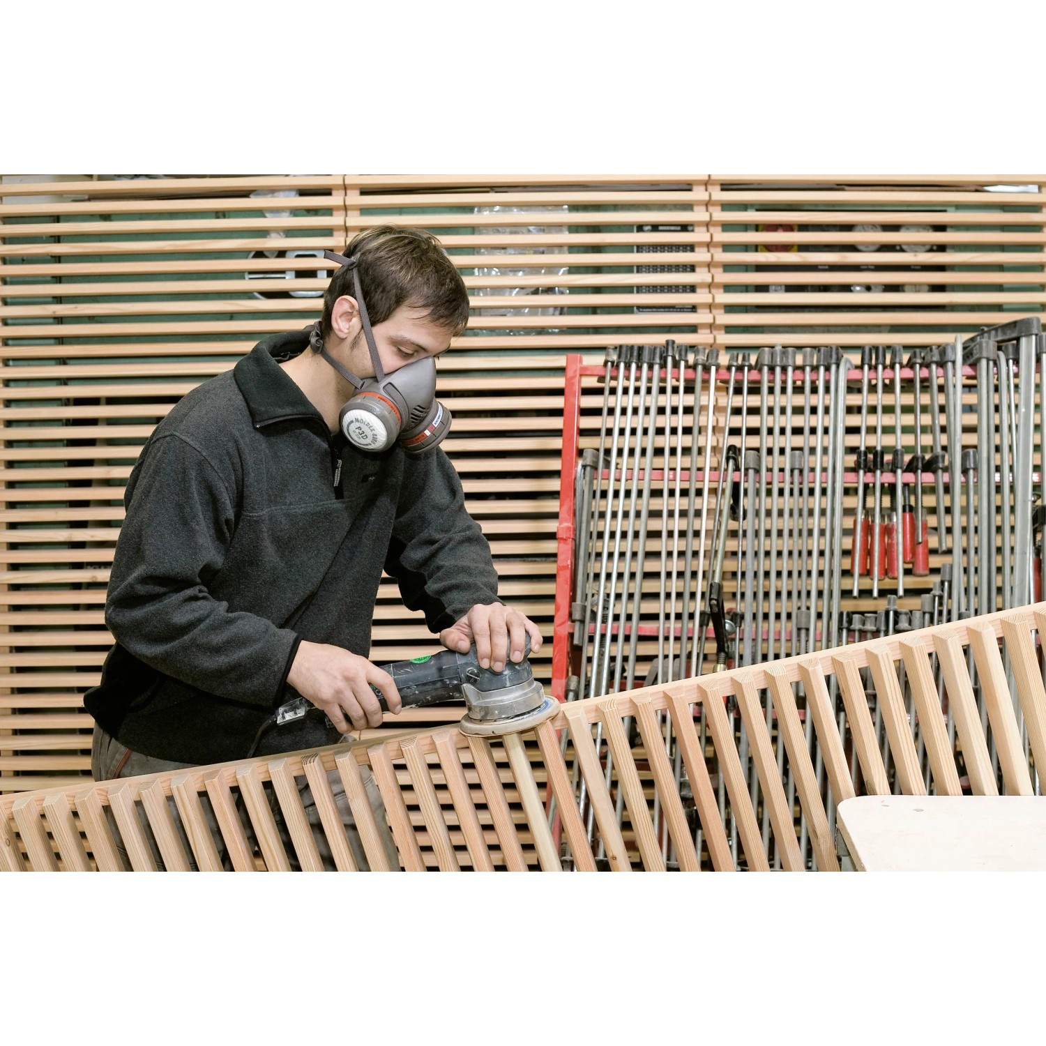 Uomo che leviga il legno con respiratore LUX P3. Filtro antiparticolato per lavorare in sicurezza.