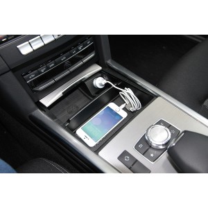 Interni auto con cellulare e cavo di ricarica nel vano portaoggetti. Accessori interni auto.