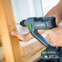 Trapano a percussione a batteria LUX A-BH-20 che fora il legno. Trapano a percussione a batteria con design grigio e verde.