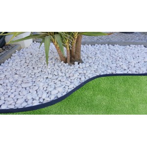 Giardino con ciottoli decorativi bianchi e prato.