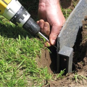 Installazione di un bordo giardino t.b.t. con un avvitatore a batteria in giardino.