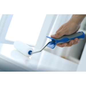 Mano che dipinge con rullo in schiuma LUX, 10 cm, con impugnatura morbida blu e nera. Rullo per verniciatura fine.