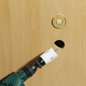 LUX Sega a tazza bimetallica 44 mm in uso con trapano su porta in legno.