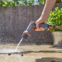 Gardena Comfort Pistola a spruzzo per pulizia ecoPulse™ in azione durante la pulizia di una superficie.
