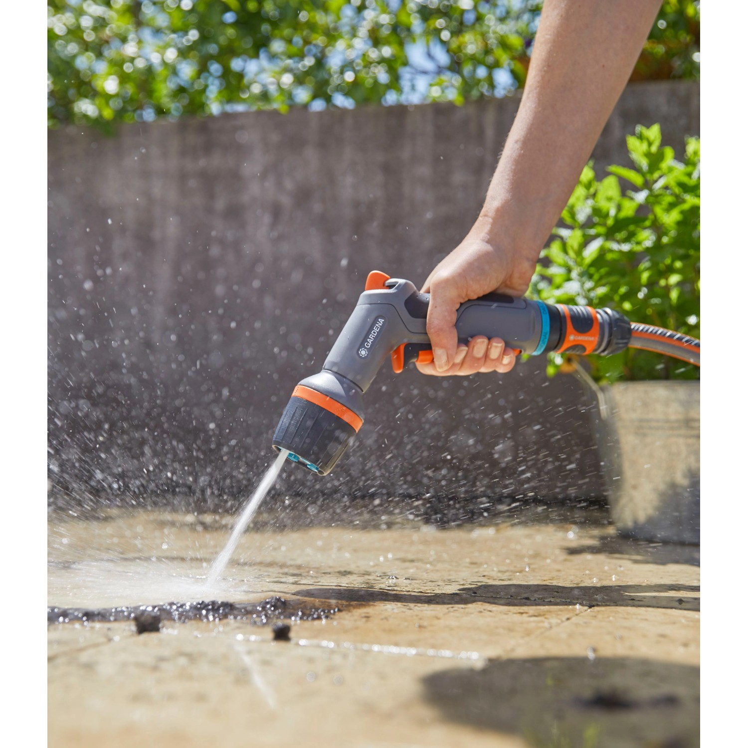 Gardena Comfort Pistola a spruzzo per pulizia ecoPulse™ in azione durante la pulizia di una superficie.