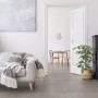 Soggiorno luminoso con pavimentazione in PVC t.b.t. grigia effetto legno.