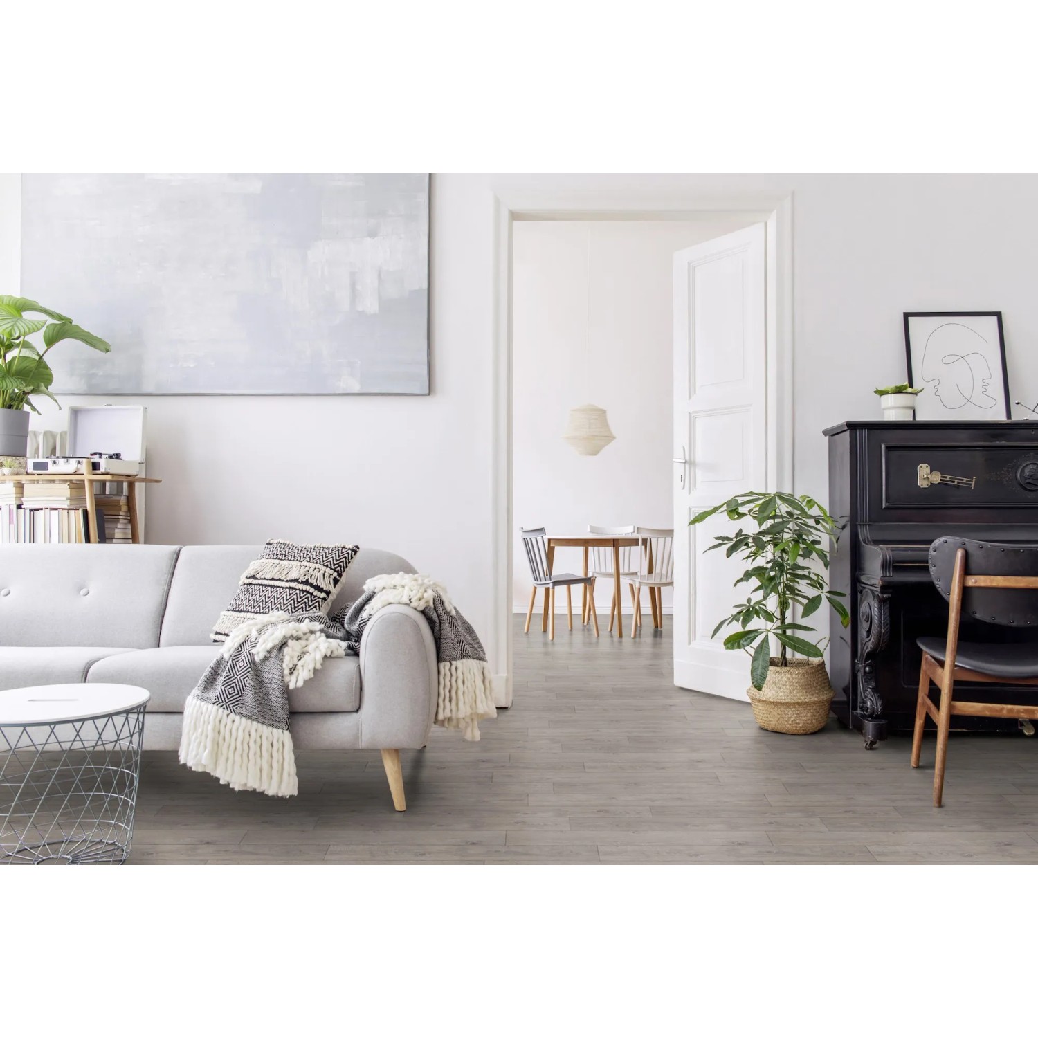Soggiorno luminoso con pavimentazione in PVC t.b.t. grigia effetto legno.