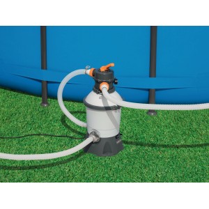 Filtro a sabbia per piscina, con tubi e piscina sullo sfondo.