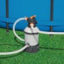 Filtro a sabbia per piscina, con tubi e piscina sullo sfondo.