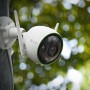 Telecamera di videosorveglianza t.b.t. bianca con due antenne sotto la pioggia.