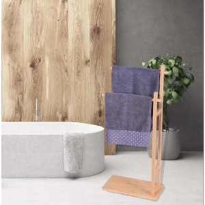 Portasciugamani freestanding in legno con due asciugamani viola in bagno.