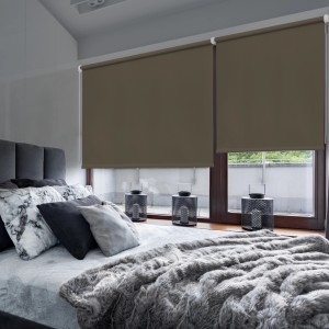 Tende a rullo t.b.t. marroni davanti alle finestre in camera da letto.