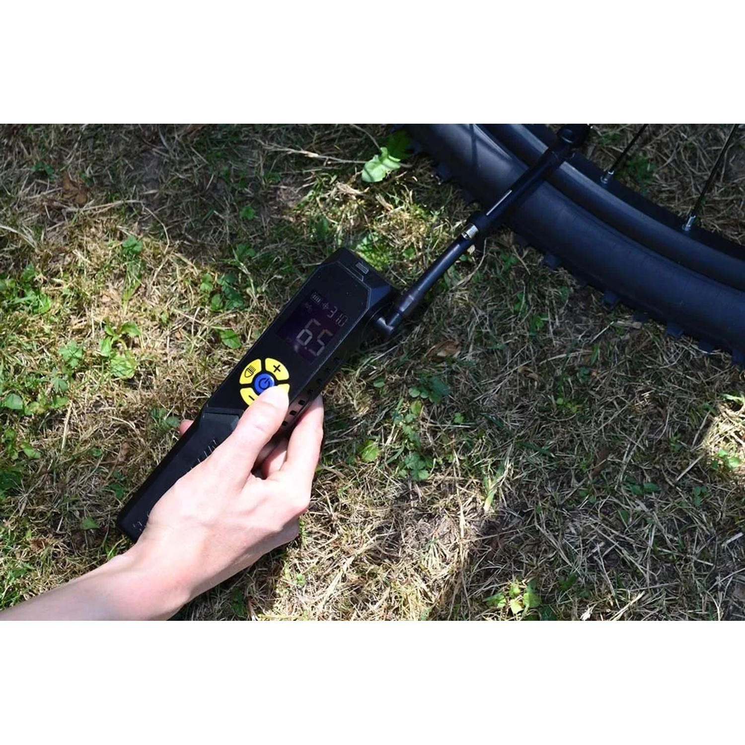 Mano tiene gonfiatore digitale per pneumatici su pneumatico bici per riparazione auto.