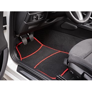 Tappetino auto nero con bordo rosso all'interno di un'auto.