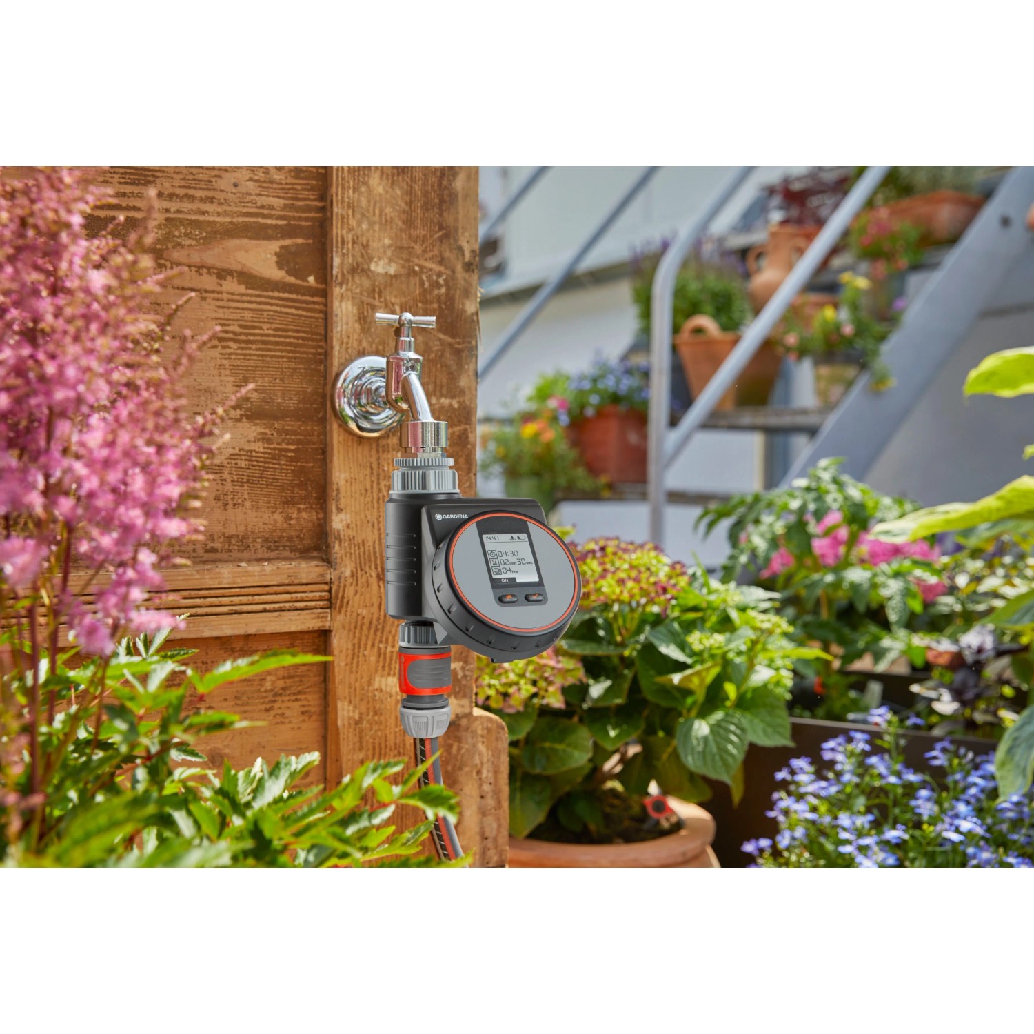 Computer per irrigazione Gardena Flex su rubinetto con tubo in giardino.