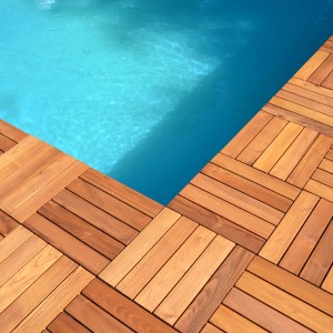 Piastrelle in legno t.b.t. attorno a una piscina, posa quadrata.
