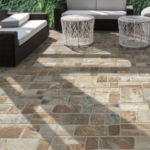 Posa di pavimentazione per esterni t.b.t. effetto pietra su una terrazza con mobili da giardino.