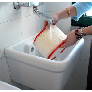 Pulizia di un filtro per polveri sotto l'acqua corrente in un lavandino.