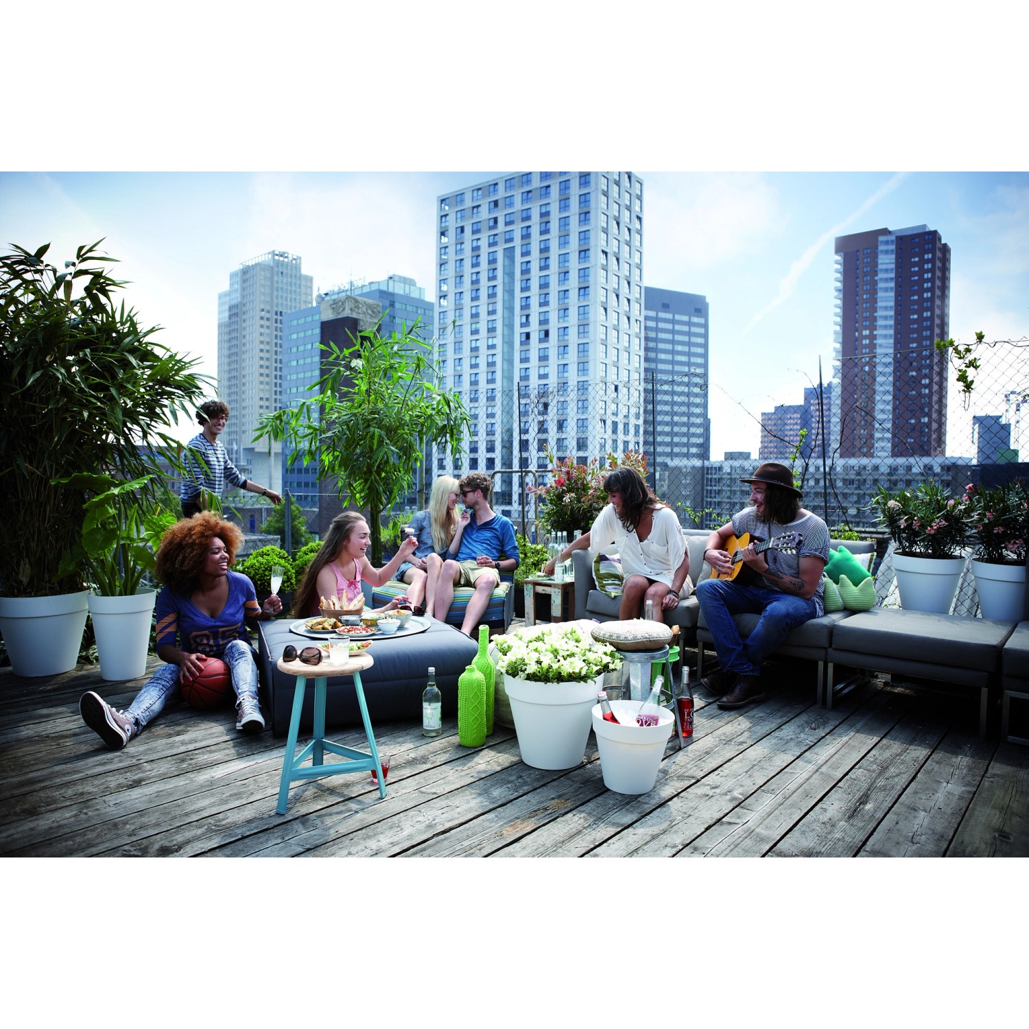 Scena con vasi da fiori Elho Loft Ø 30 cm (bianchi) su una terrazza panoramica con persone.